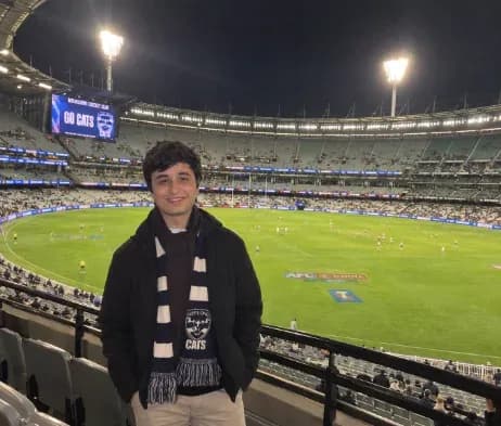 Manav at an AFL game in a Geelong Cats scarf