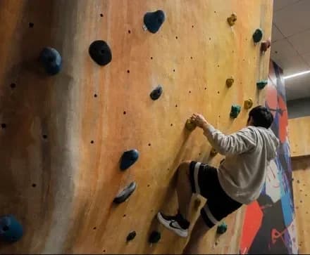 Manav climbing an indoor bouldering wall