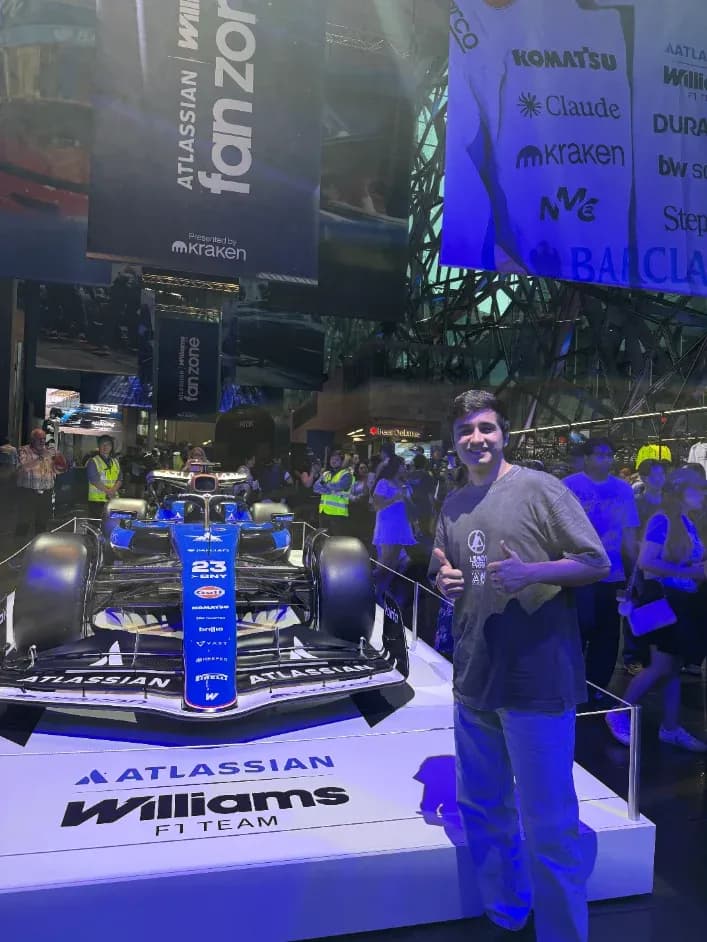 Manav next to a Williams F1 car at a fan zone